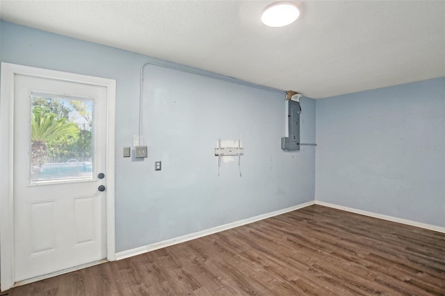 laundry room featuring a textured ceiling, wood finished floors, and baseboards