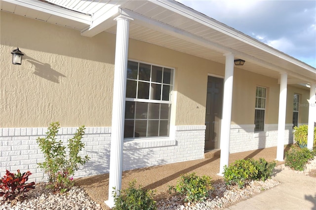 view of property exterior with covered porch and brick siding