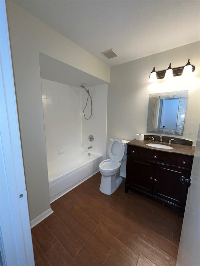 bathroom with toilet, visible vents, wood finished floors, and shower / bathtub combination