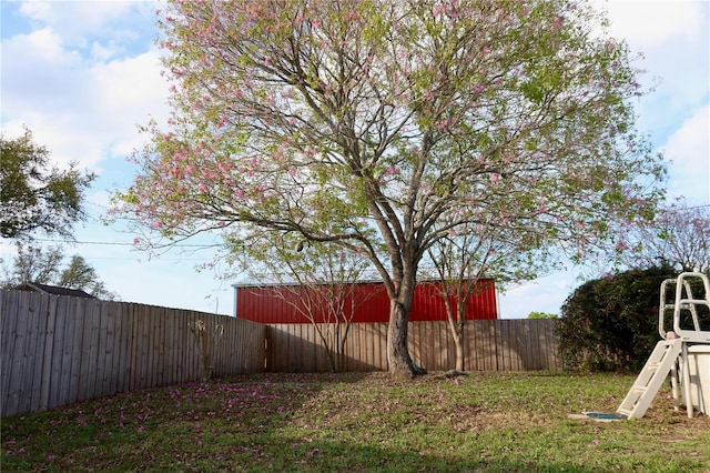 view of yard with an outbuilding, a pole building, and a fenced backyard