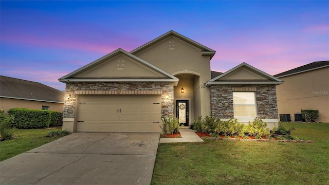 view of front of house with concrete driveway, a lawn, an attached garage, and stucco siding