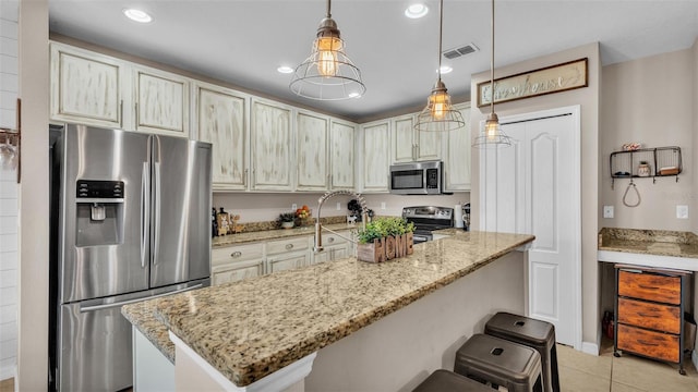 kitchen with light tile patterned floors, light stone counters, stainless steel appliances, and recessed lighting