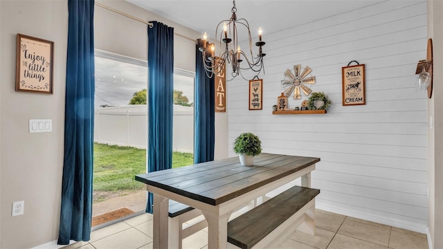 dining space with a chandelier, a wealth of natural light, and light tile patterned flooring