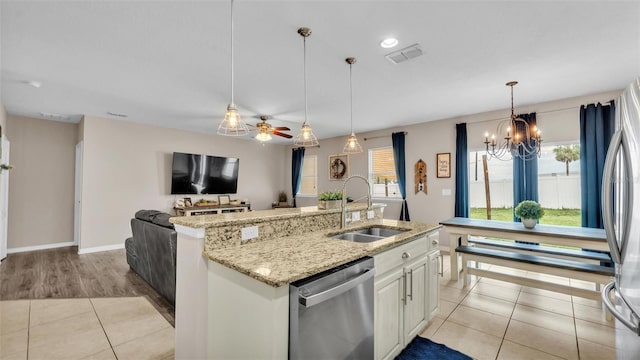kitchen featuring stainless steel appliances, visible vents, a healthy amount of sunlight, light tile patterned flooring, and a sink