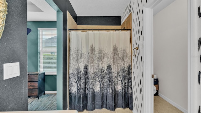 full bath with toilet, curtained shower, tile patterned flooring, and baseboards