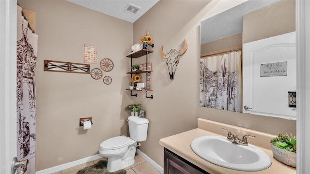 bathroom with baseboards, visible vents, toilet, tile patterned floors, and vanity