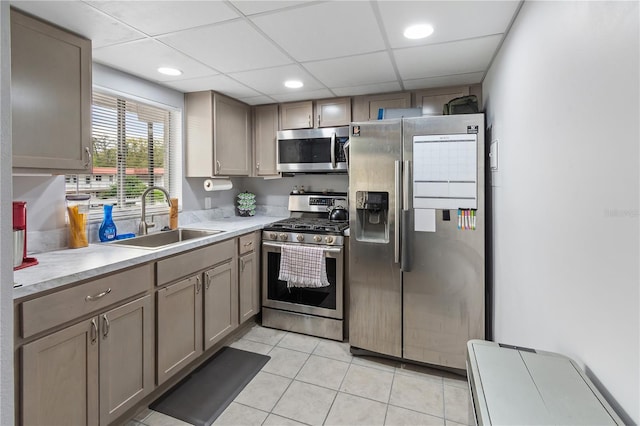 kitchen featuring a drop ceiling, stainless steel appliances, a sink, and light countertops