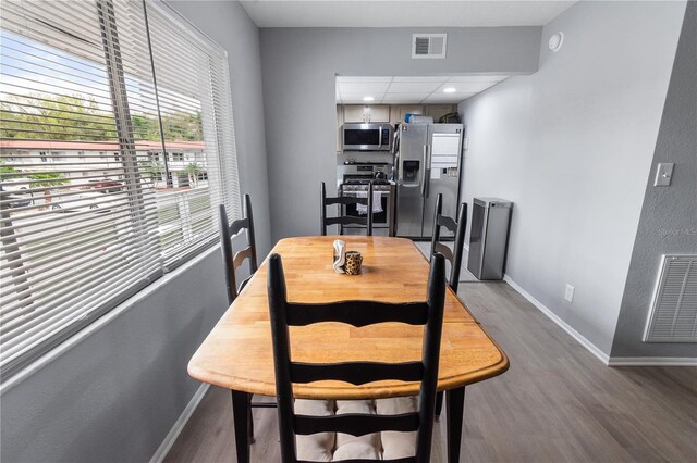 dining space with baseboards, visible vents, and wood finished floors