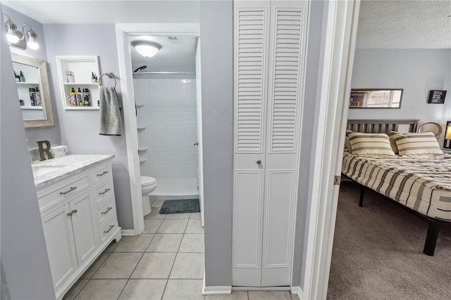 bathroom featuring a closet, a textured ceiling, toilet, and tile patterned floors