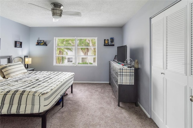 bedroom with light carpet, baseboards, ceiling fan, a textured ceiling, and a closet