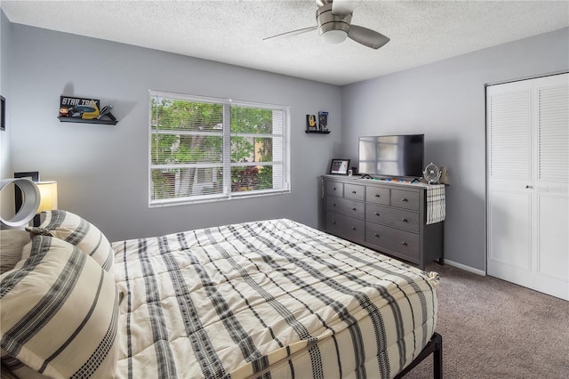 bedroom with carpet floors, a closet, a textured ceiling, and a ceiling fan