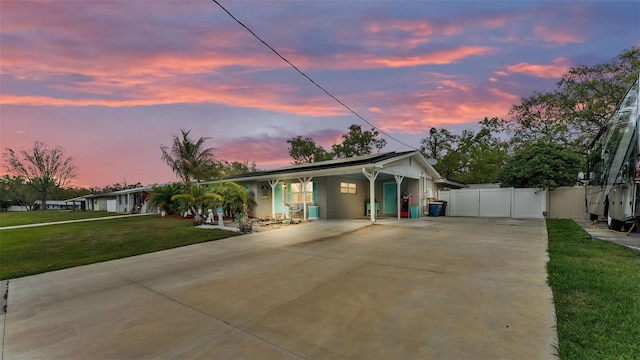 view of front of home with driveway, a gate, fence, and a lawn