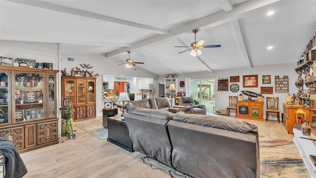 living room with visible vents, vaulted ceiling with beams, light wood-style flooring, and ceiling fan