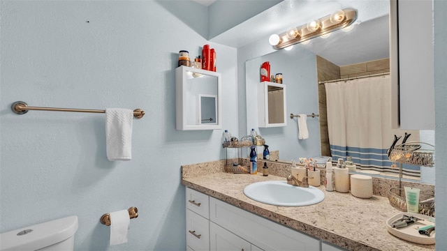 bathroom with toilet, curtained shower, and vanity