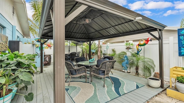 wooden deck featuring a gazebo, outdoor dining area, and fence