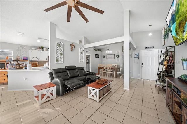 living room with light tile patterned floors, a ceiling fan, vaulted ceiling, and a textured ceiling