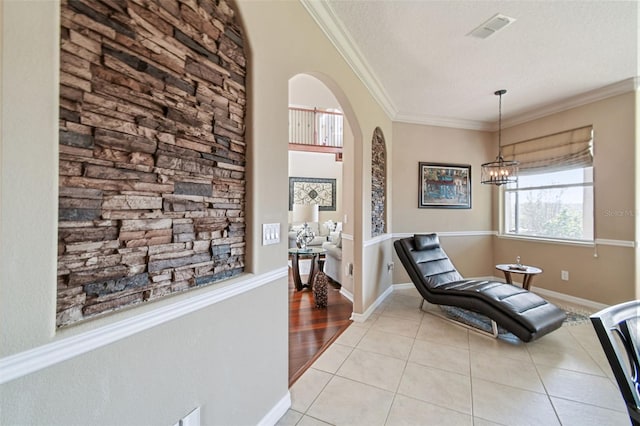 sitting room featuring arched walkways, light tile patterned floors, visible vents, ornamental molding, and a textured ceiling