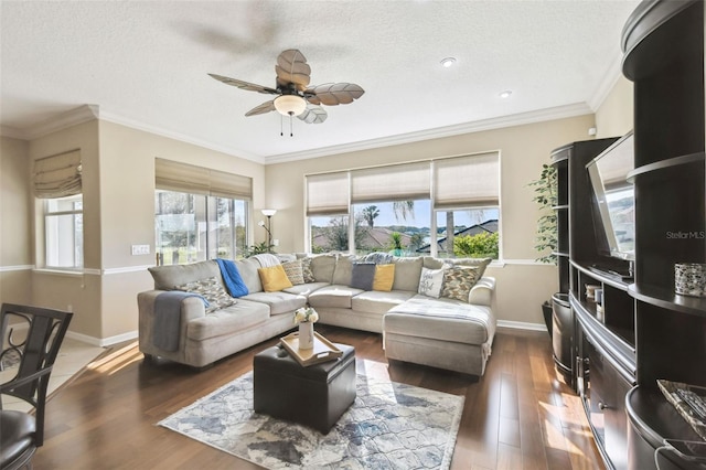 living area with ceiling fan, a textured ceiling, wood finished floors, baseboards, and crown molding