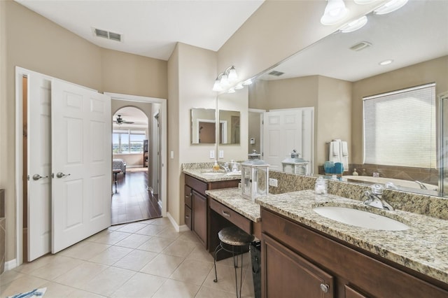 full bathroom featuring two vanities, tile patterned flooring, visible vents, and a sink