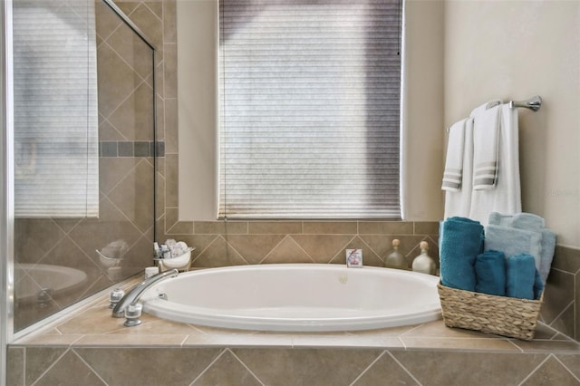 bathroom featuring a bath and tiled shower