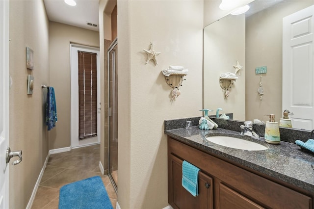 bathroom featuring a shower stall, baseboards, tile patterned flooring, and vanity