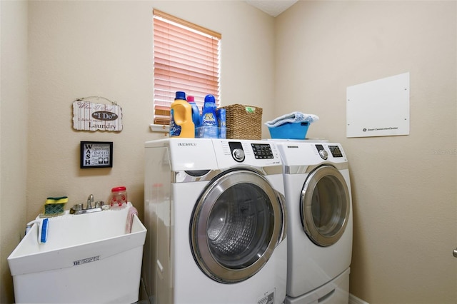 washroom with laundry area, a sink, and washer and clothes dryer