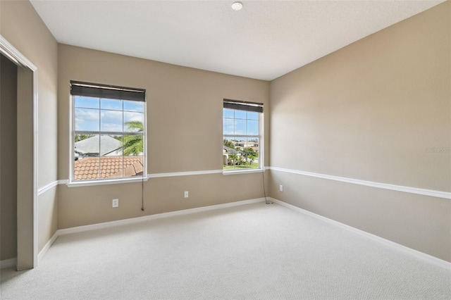 unfurnished room featuring carpet flooring, plenty of natural light, and baseboards