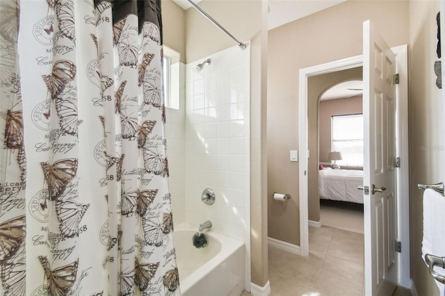 bathroom featuring ensuite bath, baseboards, shower / bath combo with shower curtain, and tile patterned floors