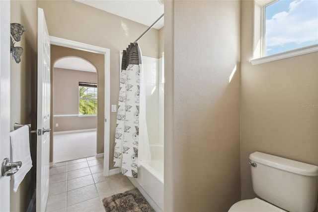 bathroom with toilet, tile patterned flooring, and shower / tub combo with curtain