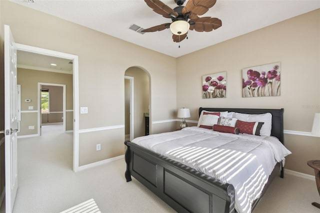 bedroom with light carpet, arched walkways, visible vents, and baseboards