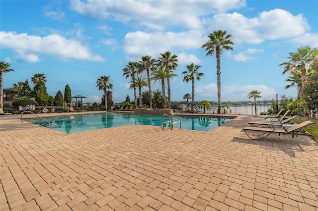 community pool with a patio and fence