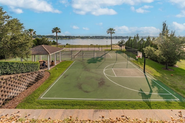 view of basketball court with a water view, community basketball court, fence, and a gazebo