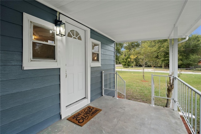 property entrance featuring a yard and a porch