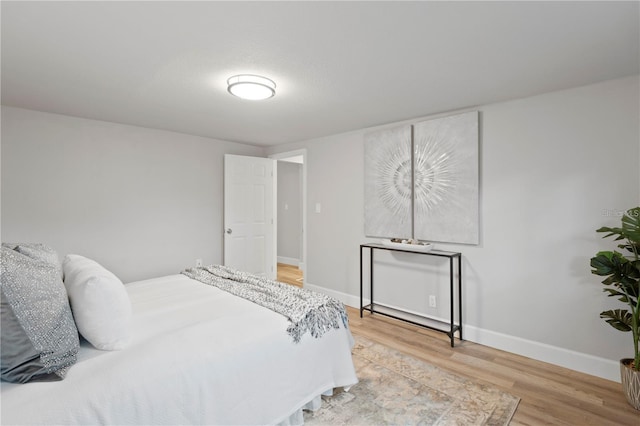 bedroom with baseboards and wood finished floors