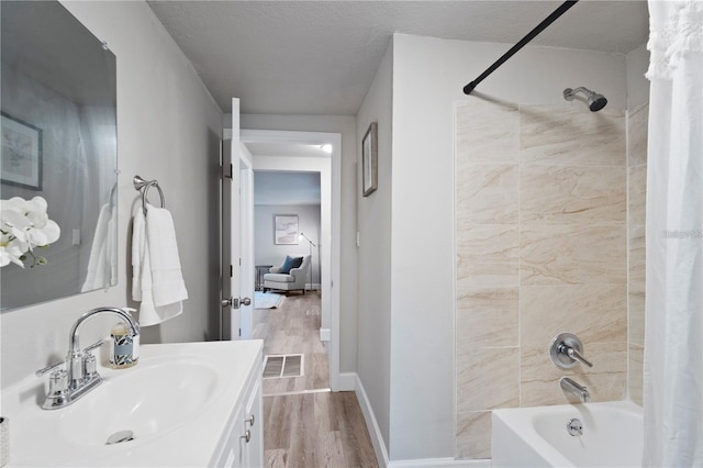 bathroom with shower / bath combination with curtain, wood finished floors, visible vents, and a textured ceiling