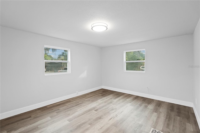 empty room featuring baseboards and wood finished floors