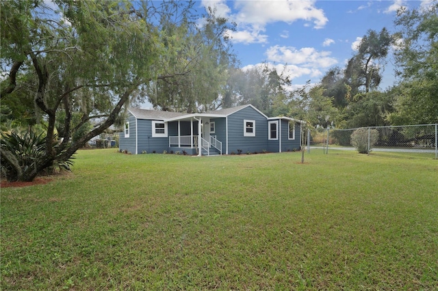 view of front of home with a front yard and fence