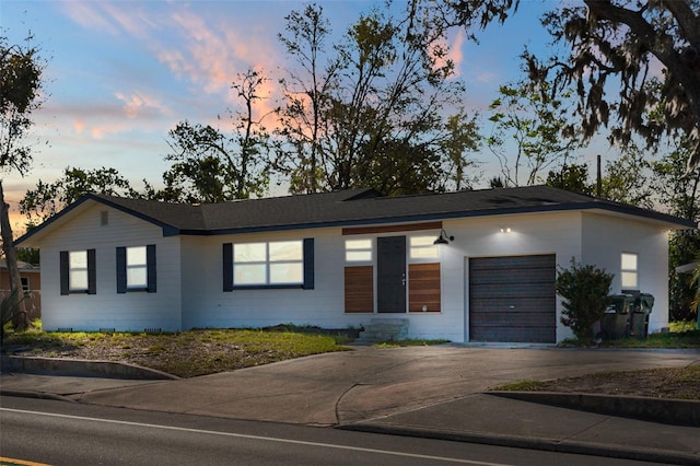 single story home with concrete driveway and an attached garage