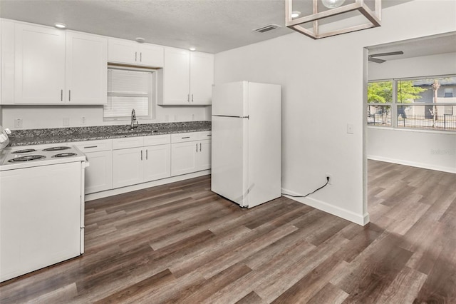 kitchen featuring white appliances, dark wood-style flooring, a sink, visible vents, and white cabinets