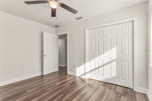 unfurnished bedroom featuring baseboards, visible vents, a ceiling fan, wood finished floors, and a closet