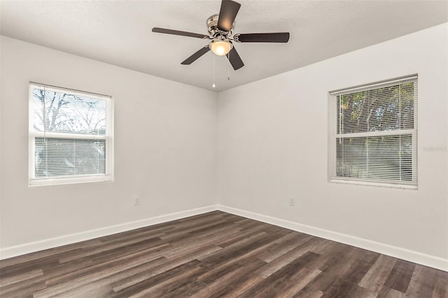 unfurnished room featuring dark wood-style floors, ceiling fan, and baseboards