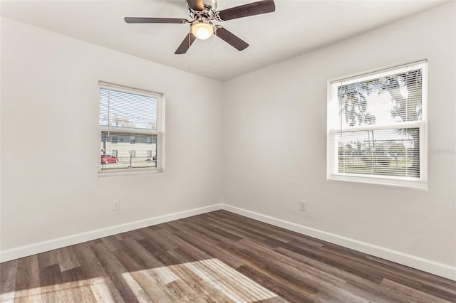 spare room with ceiling fan, dark wood finished floors, and baseboards