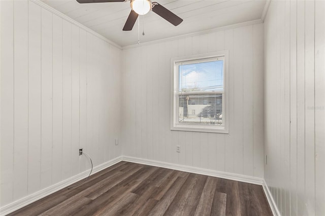 spare room featuring dark wood-style floors, ceiling fan, crown molding, and baseboards