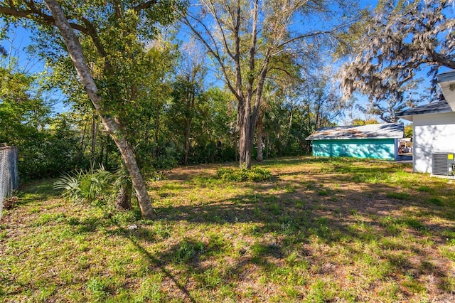 view of yard with fence and central AC unit