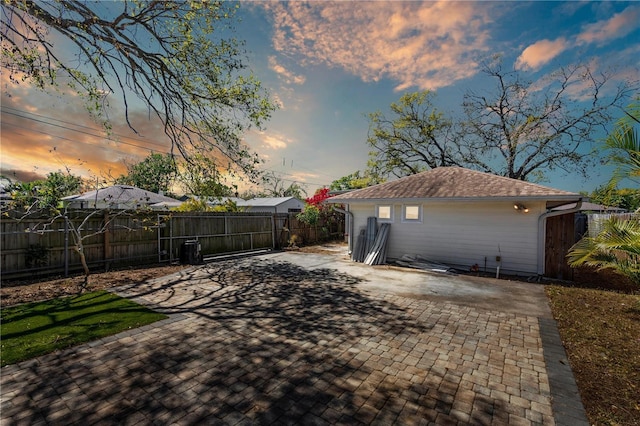 yard at dusk with fence and a patio