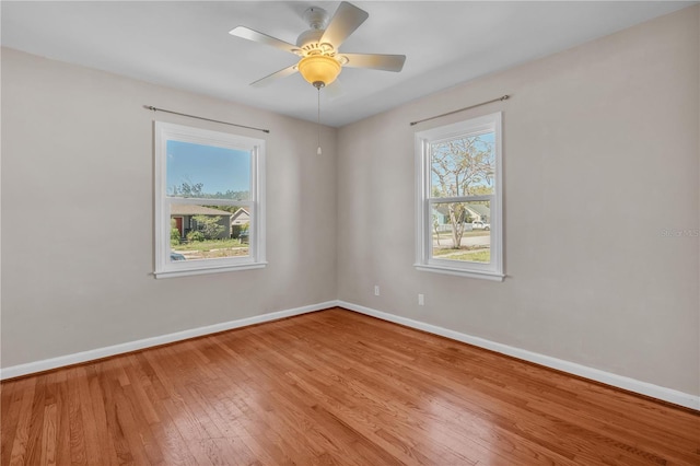 spare room featuring ceiling fan, baseboards, and hardwood / wood-style floors