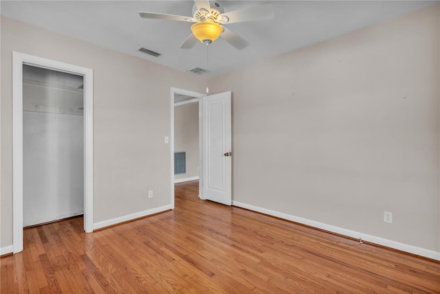 unfurnished bedroom with visible vents, a closet, baseboards, and wood finished floors