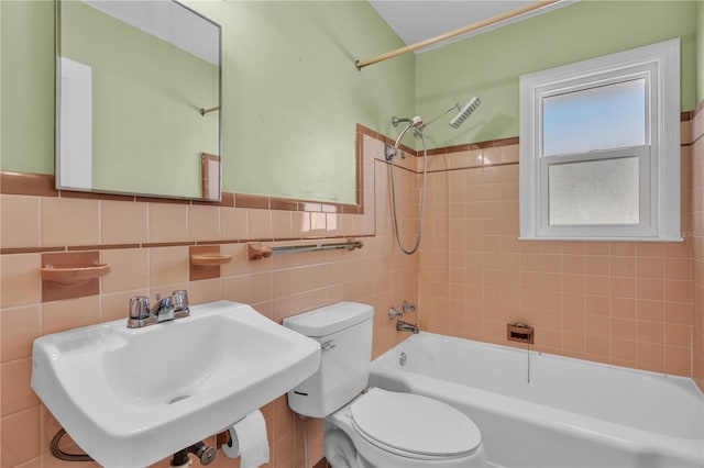 bathroom with shower / bath combination, a sink, toilet, and tile walls