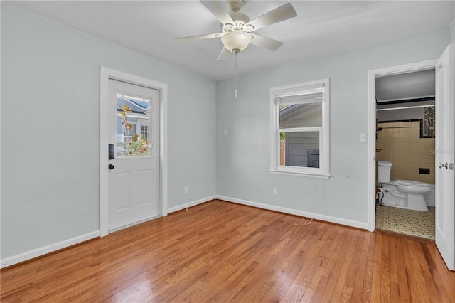 unfurnished bedroom with a ceiling fan, light wood-type flooring, baseboards, and ensuite bathroom