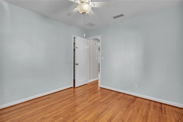 empty room featuring light wood-style floors, visible vents, ceiling fan, and baseboards